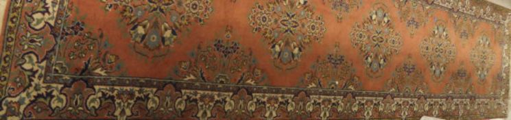 A Persian runner, the five floral decorated medallions in pale blue, pale green,