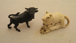 A simulated ivory netsuke in the form of a rat upon a sack,