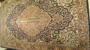 A Persian rug, the central medallion with Tree of Life decoration in cream, salmon and pale blue,