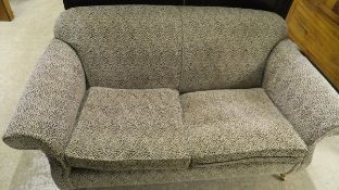 A pair of modern two-seat scroll arm sofas upholstered in cream and black chenille fabric