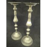 A pair of large pricket candlesticks with patinated brassed finish