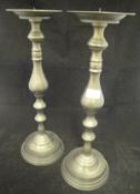 A pair of large pricket candlesticks with patinated brassed finish