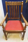 An mid 20th Century oak framed elbow chair on barley twist front legs united by stretchers,