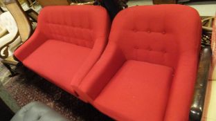 A modern two seat sofa with buttoned back and plain red upholstery,