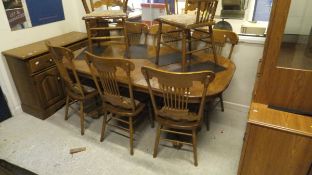 A 20th Century oak extending D end dining table and eight stick back chairs (6 plus 2),