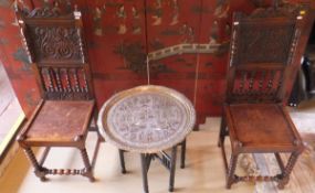 A pair of oak hall chairs with carved backs, on bobbin turned legs united by stretchers,