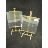 A pair of photograph frames in the form of artist's easels with adjustable lacquered brass frames