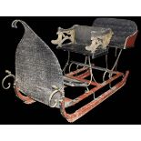 A late 19th Century Continental painted and gilded upholstered sleigh with driver's seat and two