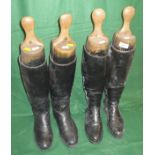 Two pairs of black leather riding boots with wooden trees