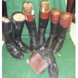 A pair of black and tan hunting boots with wooden trees and brass fittings together with two