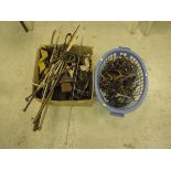 A box and basket containing assorted leather bridles, head collars, various bits, whips etc.