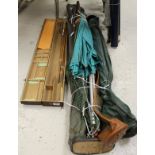 A collection of three fishing umbrellas, three rod holdalls, a landing net,