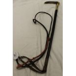 A child's riding crop with antler handle and plaited ferrule above a plaited shaft and thong