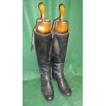 A pair of black leather riding boots with wooden trees bearing ivory plaque inscribed "Rowell &