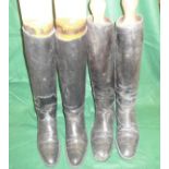 Two pairs of black riding boots and wooden trees