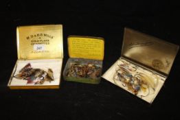 Three tins containing a collection of gut eyed dressed salmon flies