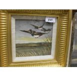 A framed and glazed ceramic tile with hand painted decoration of mallard coming in over reed beds