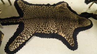 An early to mid 20th Century mounted Leopard skin rug with half head (paws and most whiskers