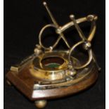 An ink well stand in the form of a horseshoe and bit raised on an oak plinth base to ball feet