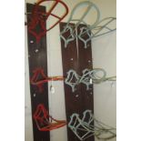 Nine painted saddle racks mounted in threes on wooden boards together with a collection of mounted