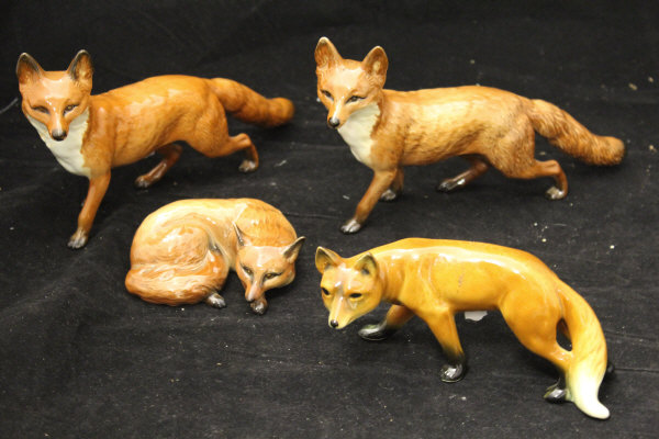 Three Beswick figures of foxes and one further West German figure of a fox