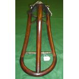 A stripped iron saddle rack with mahogany mounts