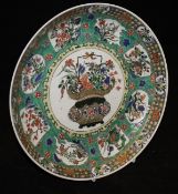 A Chinese Kangxi Famille Verte shallow dish with central basket decoration within a mottled band of