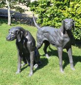A pair of modern chocolate brown patinated bronze figures of hounds, one standing, one seated,