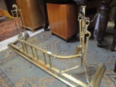 A Victorian brass fender with integral fire tool holders,