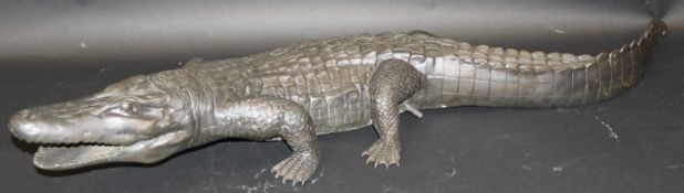 A modern chocolate brown patinated bronze fountain head as a crocodile