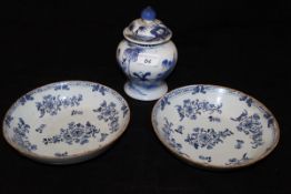 A pair of 19th Century Delft blue and white shallow bowls decorated with floral sprays,