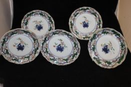 A collection of five Japanese polychrome decorated plates with central vase of flowers within a