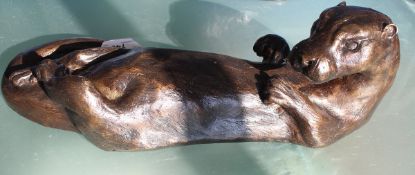 A modern chocolate brown patinated bronze figure of an otter swimming upon it's back,