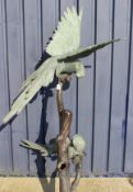 A modern bronze figure group of three macaws upon a stump, verdigris patination,