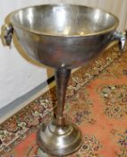 A polished metal floor-standing champagne cooler of trophy cup form*