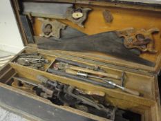 A late Victorian stained pine woodworkers chest and contents of various tools to include saws,