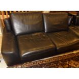 A pair of black leather sofas on chrome legs