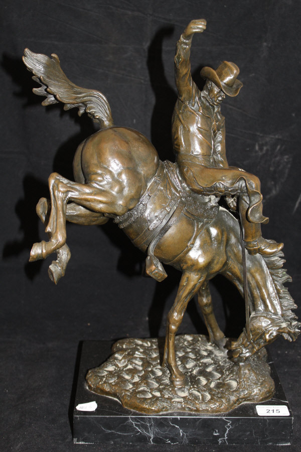 A modern bronze study of a rodeo rider on a black marble base