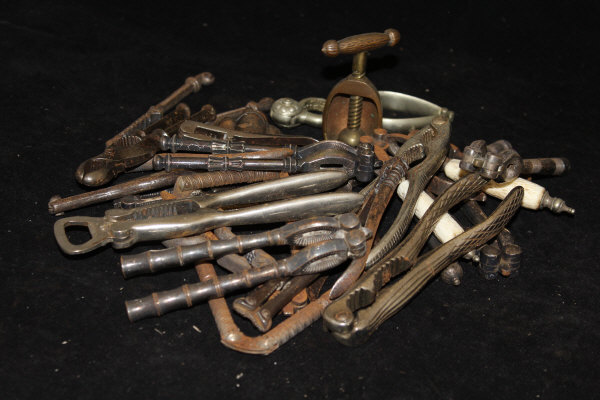 A box containing various steel and other nutcrackers of twin-handled form together with two screw