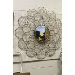 A circular wall mirror with metal flower petal decorated frame