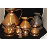 A collection of eight graduated copper haystack measures,