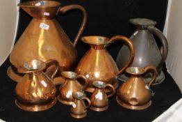 A collection of eight graduated copper haystack measures,