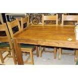 A modern oak rectangular dining table raised on square legs,