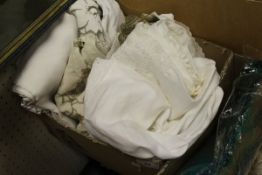 A box containing assorted linen to include various place mats, tablecloths,