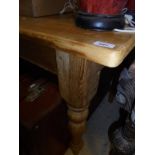 A rectangular pine kitchen table on turned supports