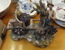 A large capo-di-monte figure group of a grape picker with donkey and boy in cart,