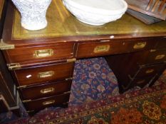 A 20th Century mahogany and brass bound military style double pedestal desk with tooled and gilded