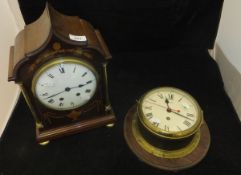 A mahogany cased and inlaid mantle clock with brass column supports,