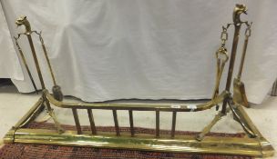 A Victorian brass fender with integral fire tool holders,
