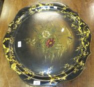 A Victorian black laquered papier mâché gilt decorated and floral spray painted circular tray